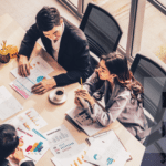 Marketers gathered together reviewing business charts on a screen